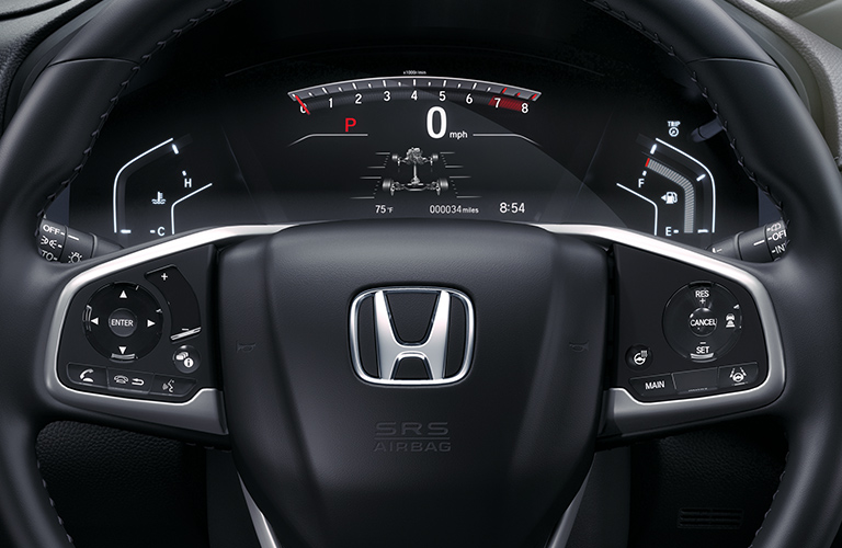 Close-up on a steering wheel and dashboard display inside a Honda