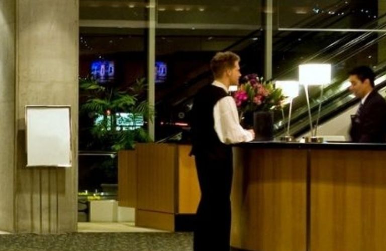 A person talking to a hotel receptionist at the lobby